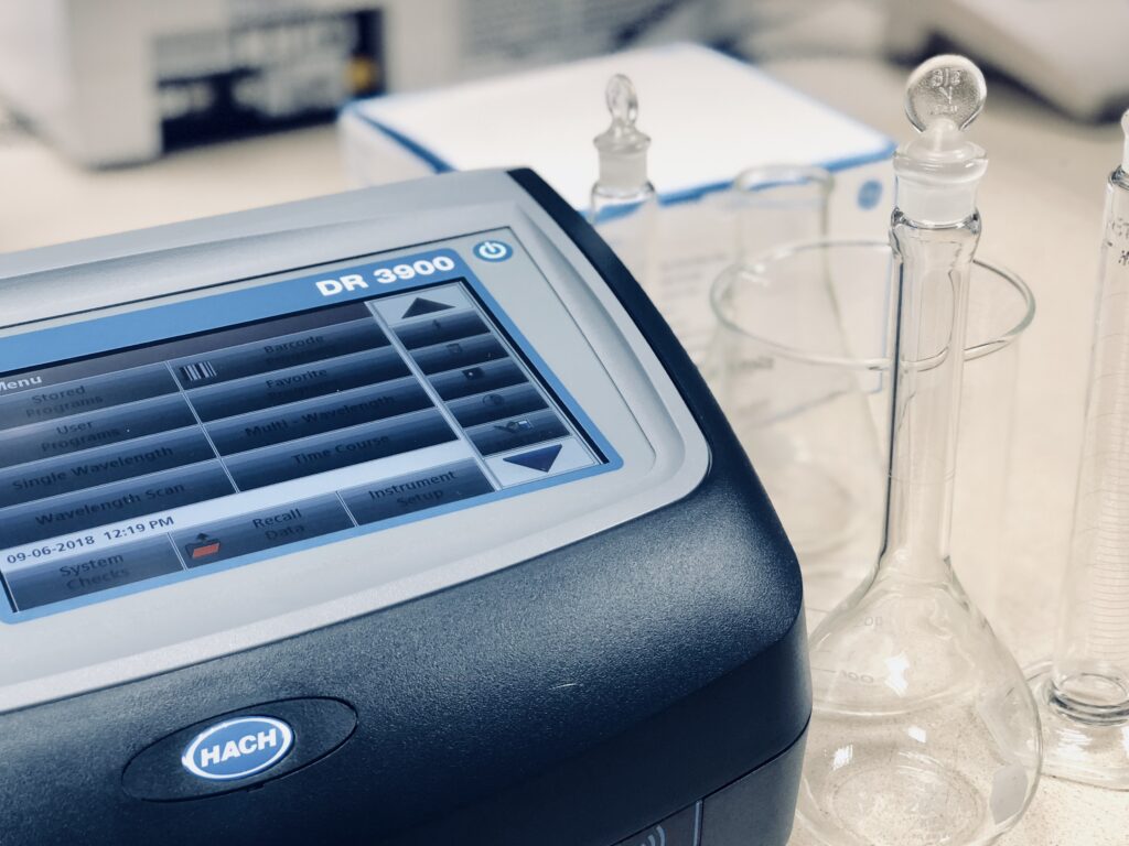 Hach DR 3900 filtration software machine left of a glass beaker